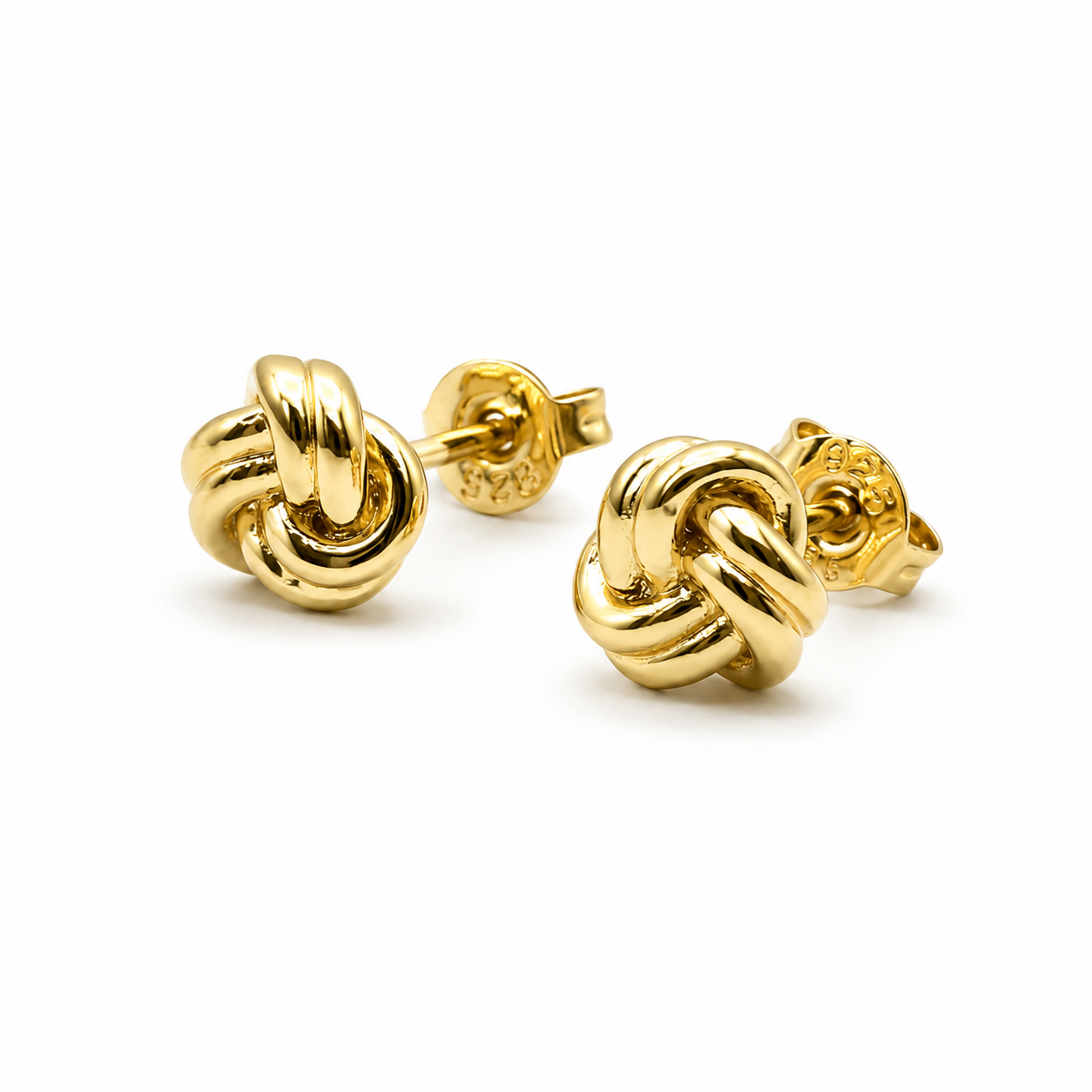 Gold knot earrings on a white background