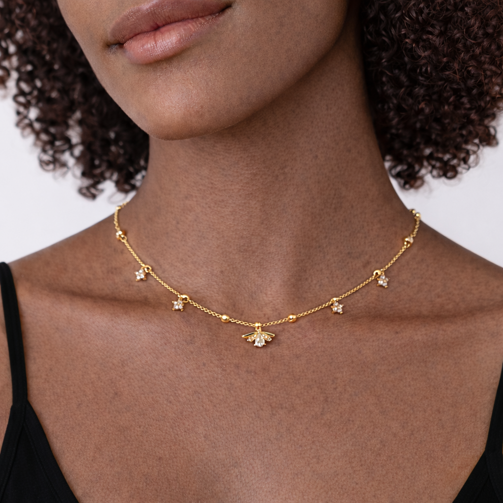 A woman wearing lotus necklace with small flowers and black clothing. he necklace is made of 18K Gold Vermeil coated Sterling Silver