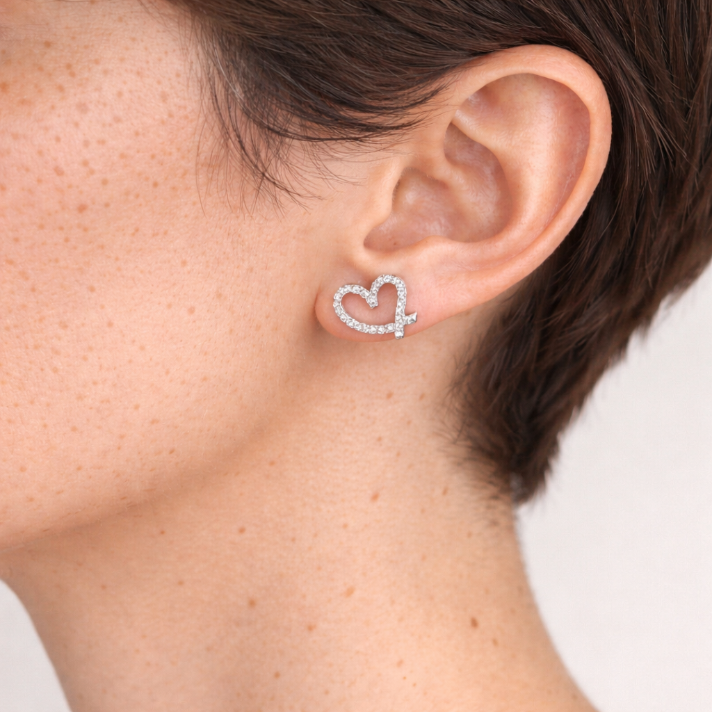 A woman's sideview ears showcasing a heart shaped stud earrings with zirconia stones.