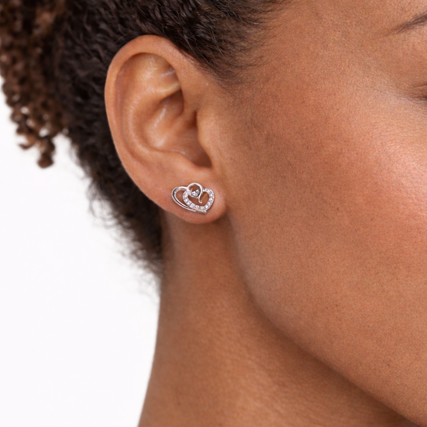 Close-up of a woman wearing a heart-shaped earring on a white background